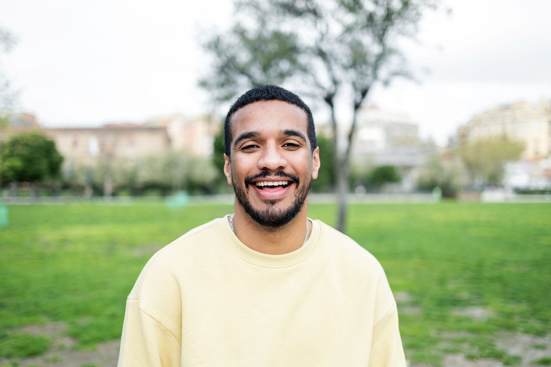Young man smiling and enjoying a day in the park